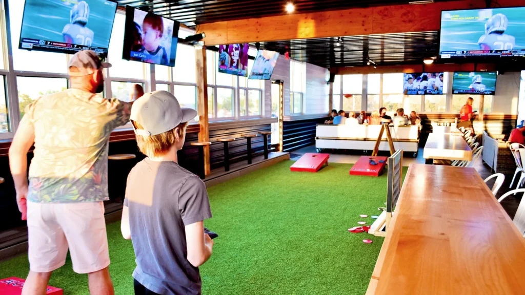 Interior of Boom restaurant in Grove. Oklahoma showing father and son playing cornhole